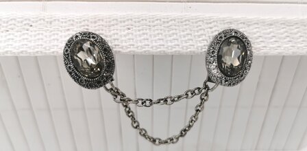 Clips mit doppelter Kette aus ovalem Kristall mit verziertem Rand in Antik-Silber-Optik.