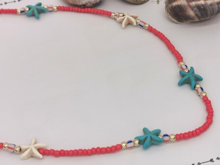 Ketting rood kralen met blauw en witte zeester van edelsteen