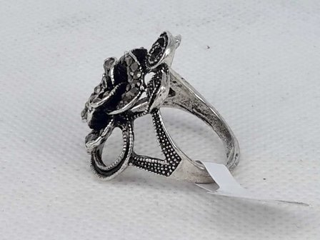 Antiek zwart kleur ring in vorm als roos met takjes met veel klein kristal.