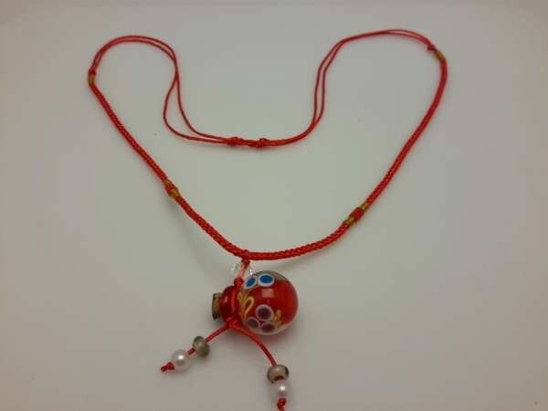 Touwketting, rood, hanger: rood bolvormig muranoflesje, facetkraal en diverse kralen