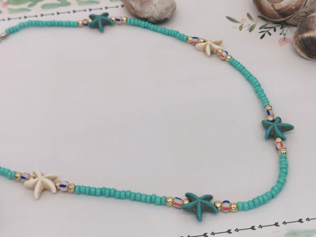 Ketting turquoise kleur kralen met edelsteen blauw en witte zeester.